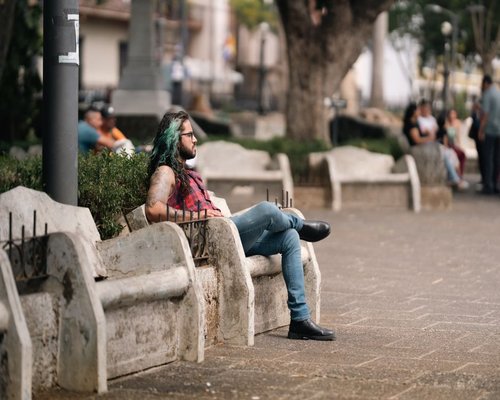person sitting and resting on a bench in a Colombian park